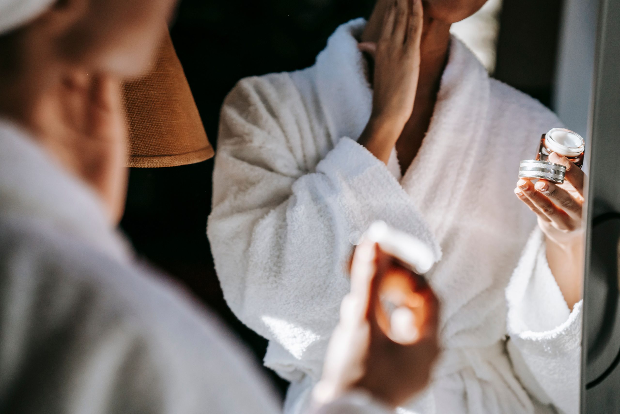 Femme souriante appliquant une crème sur son visage