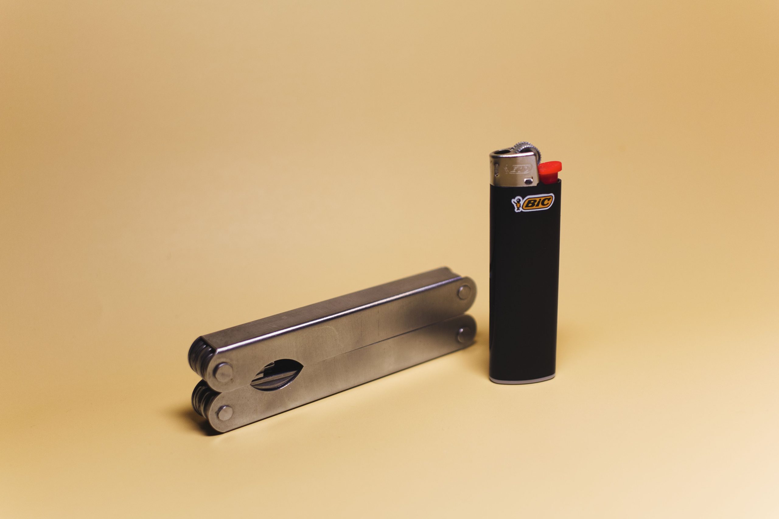 Briquet noir et multi-outil métallique sur fond jaune