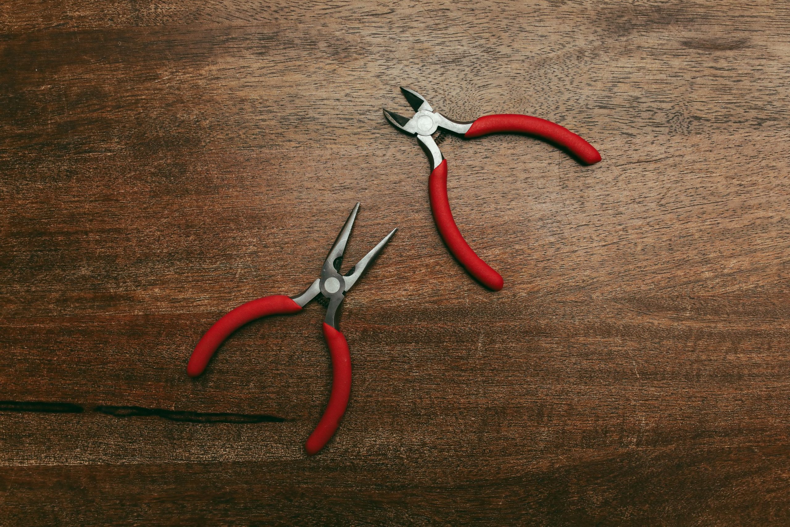 Pinces à poignées rouges sur surface en bois