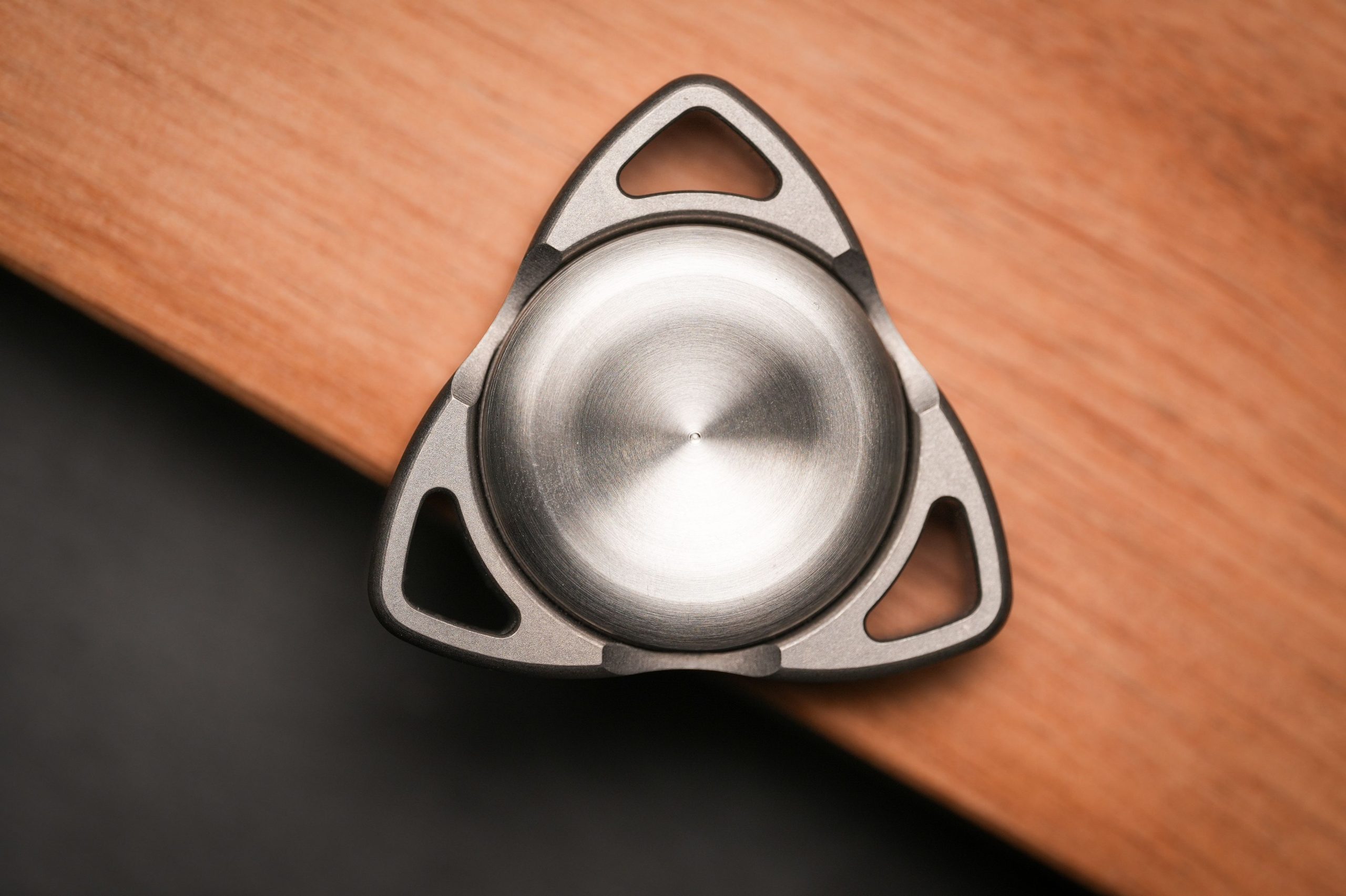 Stylo spinner métallique posé sur une table en bois